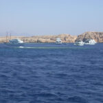 Barche da immersione all'ancora davanti alle falesie chiare di Ras Mohammed, sopra Shark e Yolanda Reef