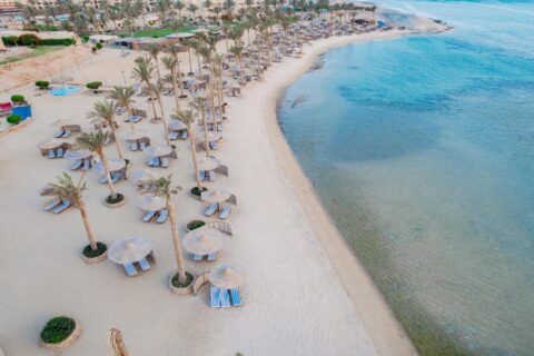 Vista aerea della spiaggia del Blend Elphistone Resort, con le palme, gli ombrelloni di paglia e il mare turchese