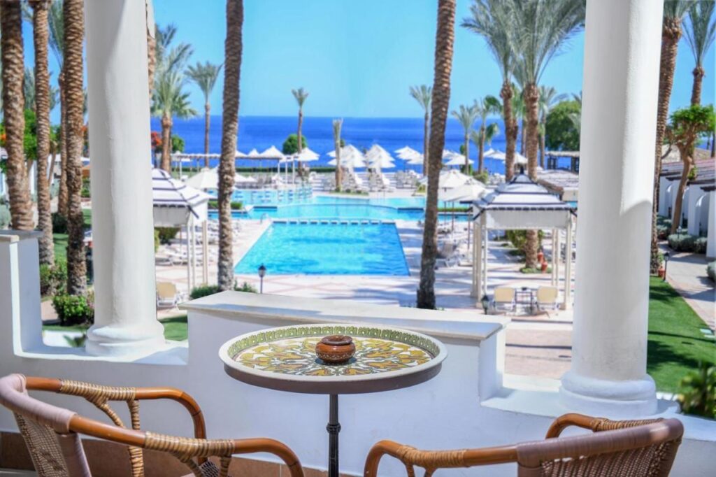 La vista da una terrazza del JAZ Fanara Resort sulle piscine, le palme e il Mar Rosso