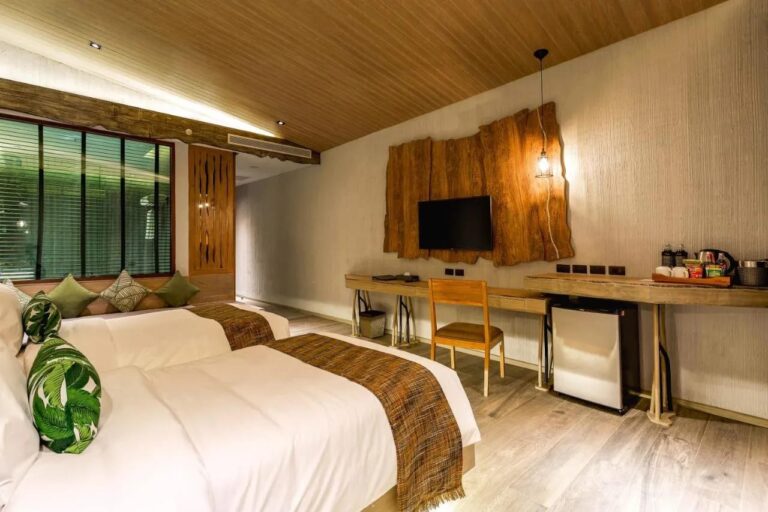 Una camera con due letti, una panca sotto la finestra, una scrivania e un vassoio per il tè