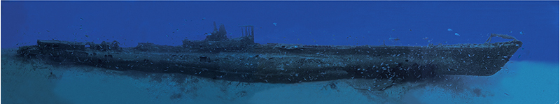 Panoramica subacquea di tutta la lunghezza del relitto del Rubis, adagiato dritto sulla sabbia, con la torretta al centro, in un'acqua blu punteggiata di pesci.
