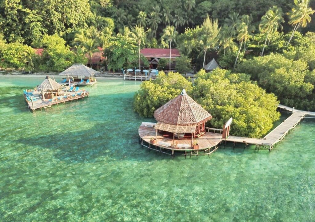 Vista aerea del Raja Ampat Dive Lodge, con i pontili su palafitte e i tetti rossi sotto le palme