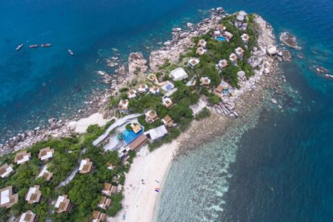 Vista aerea del Sai Daeng Resort, con i bungalow su una punta rocciosa, le piscine e la spiaggia di sabbia