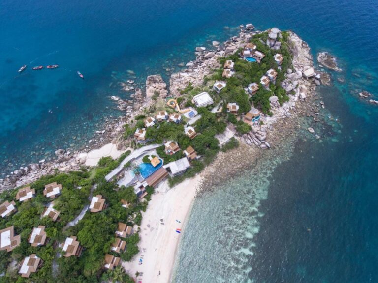 Vista aerea del Sai Daeng Resort, con i bungalow su una punta rocciosa, le piscine e la spiaggia di sabbia