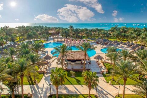Vista aerea del Siva Grand Beach, con le piscine tra le palme e il Mar Rosso con barche all'ormeggio