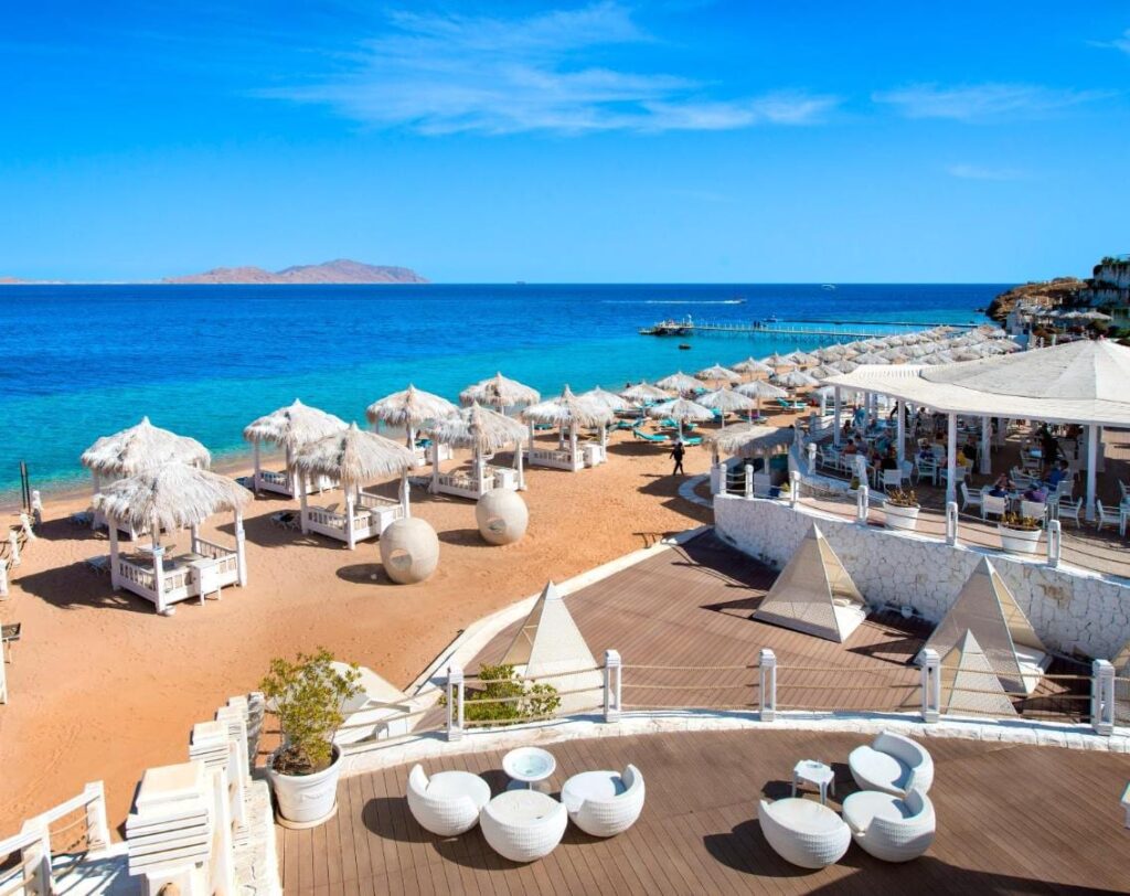 La spiaggia del Sunrise Arabian Beach Resort, con gli ombrelloni di paglia e il pontile, di fronte all'isola di Tiran