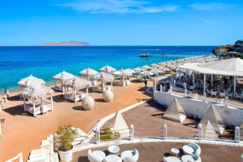 La spiaggia del Sunrise Arabian Beach Resort, con gli ombrelloni di paglia e il pontile, di fronte all'isola di Tiran